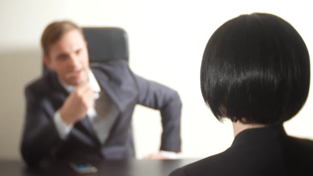 a man in a suit asks questions to a brunette woman in an interview. 4k. interview. recruitment