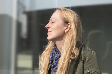 Mujer relajada con los ojos cerrados disfrutando del sol.