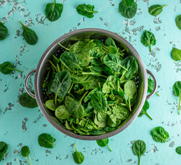 green spinach leaves in an iron colander