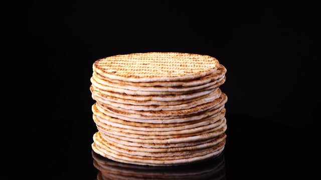 Traditional tasty flat bread (lavash, pita, chapati, scone) rotating against black background in 4K. Food texture with free space for text.
