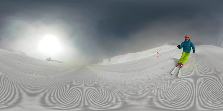 360VR 4K man and woman skiing on ski piste on sunny winters day in mountains
