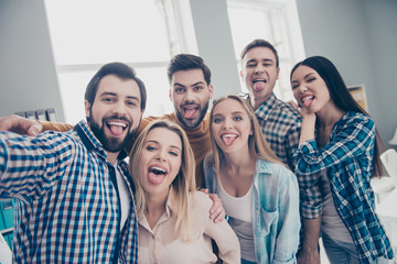 Self portrait of stylish foolish comic attractive crazy funny economists, students, financiers, lawyers in casual outfit shooting selfie on front camera showing tongue out, embracing