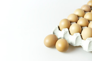 Raw chicken eggs in paper  container on isolated background.