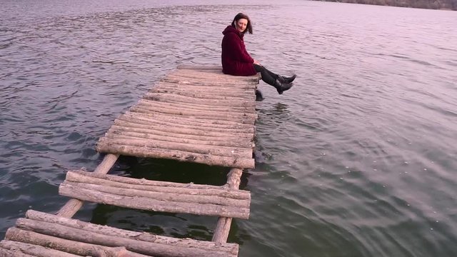 Beautiful woman sitting on a old bridge