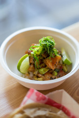 salmon poke over coconut rice topped with seaweed and lime