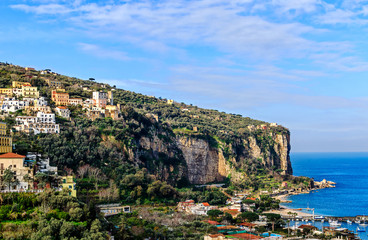 Fototapeta na wymiar Malerische steile Felsenküste mit bunten Häusern und der kleine Hafen von Vico Equense, nahe Neapel, Italien