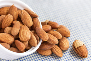 Roasted almonds, salt in bowl of white on the tablecloth. selective focus,