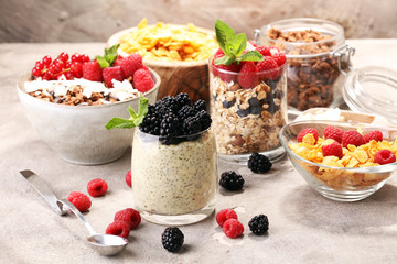 Cereal and ingredients for a healthy breakfast with chia pudding, granola, cornflakes and berries