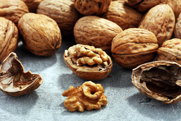 Walnut kernels and whole walnuts on rustic old table