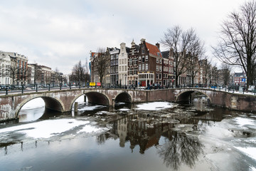 Stunning view of Amsterdam canal frozen with snow during the cold wave in February 2018 on a very cold winter day.