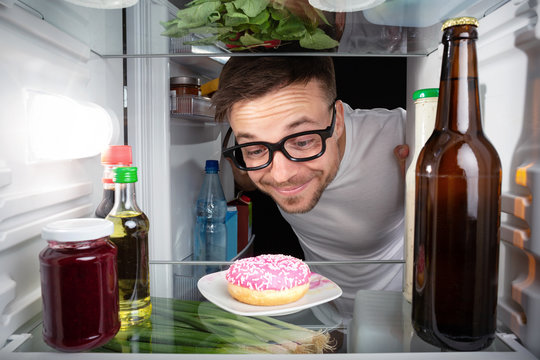 Nerd freut sich &uuml;ber einen Donut im K&uuml;hlschrank