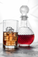 Bottle whiskey and Glass of whiskey with ice and light blurred background