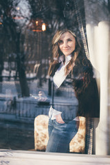 View through the window of a successful woman using a mobile phone.