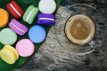 french macaron and cup of hot coffee on wooden table 