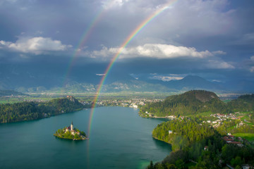 Naklejka na ściany i meble Scenic panoramic view of Lake Bled from above with double rainbow on the sky