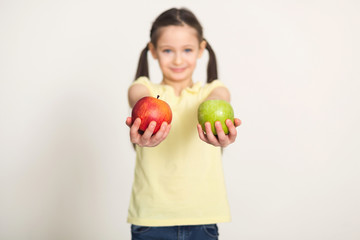 Fototapeta na wymiar Pretty cute little girl with apples over white background