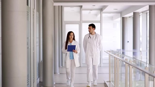 Young Doctor Colleagues Walking Through Hospital Indoor