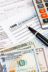 Fototapeta premium Tax form with calculator, pen, and dollar banknote