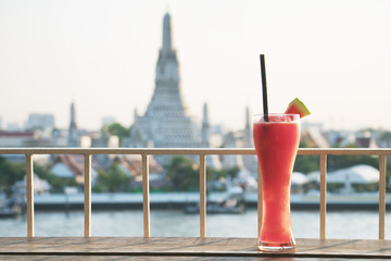  Watermelon on wooden floor,blurred background of Wat Arun, Bangkok, Thailand.