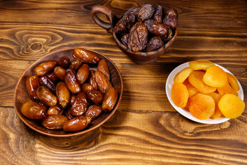 Dried apricots and dates fruit on wooden table