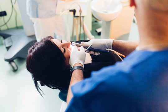 Dentist carrying out dental procedure on female patient