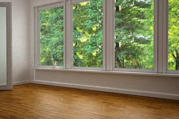 Leeres Zimmer mit großer Fensterfront mit Blick auf grüne Bäume