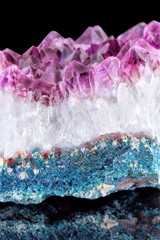 Crystal Stone macro mineral with small depth of field. Purple rough amethyst quartz crystals on black background