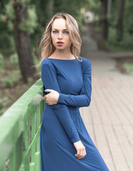 portrait of a beautiful girl in a blue dress outdoors