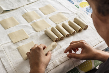 Woman making cannelloni in her kitchen