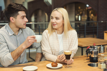Happy young couple drinking coffee at cafe