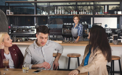Happy young friends drinking coffee at cafe