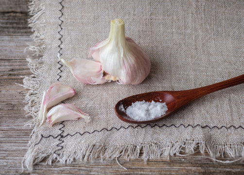 garlic and a spoon of salt on a linen napkin