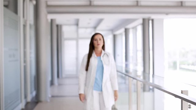 Young Female Doctor Walking Through Hospital Indoor