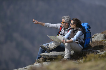 Hikers reading map and pointing at scenery