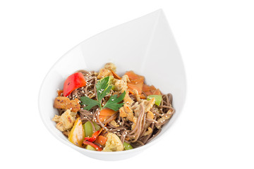 Buckwheat noodles with chicken and vegetables with teriyaki sauce isolated on white background. Buckwheat noodles in a white plate.