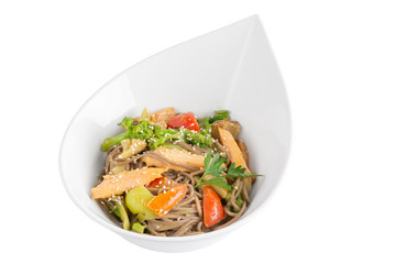 Buckwheat noodles with salmon and vegetables with teriyaki sauce isolated on white background. Buckwheat noodles in a white plate.
