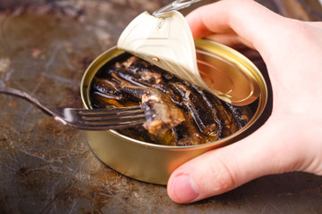 Fish can with can opener on wooden table