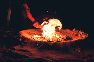Detail of a hand making a bonfire on the beach, Long Beach, Ko Lanta, Thailand.