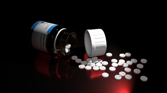 Small white drug pills and a thick glass drug bottle on a table with deep and sharp shadows and a red reflection, symbolizes dangers and problems associated with drugs, pills overdose.