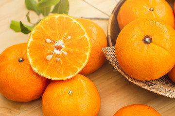 ranges group freshly picked on a brown wooden table.Fresh oranges fruit with leaves on wooden table.