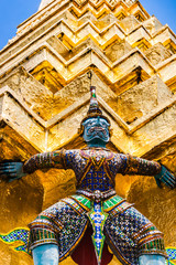 Fototapeta premium Statue of demon holding up the Golden chedi at the Wat Phra Kaew Palace, also known as the Emerald Buddha Temple. Bangkok, Thailand.