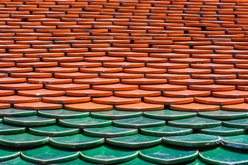 Pattern of red and green tiles on a roof. Wat Phra Kaew Palace, also known as the Emerald Buddha Temple. Bangkok, Thailand.