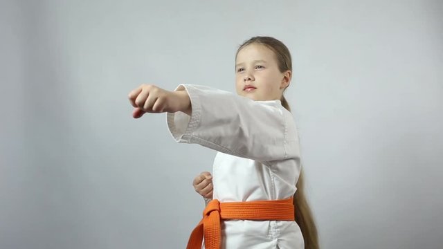 With an orange belt, sportswoman trains a punch