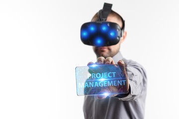 Business, Technology, Internet and network concept. Young businessman working in virtual reality glasses sees the inscription: Project management