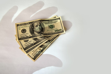 Shadow of the hand falls on money in dollars