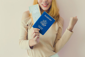 Fototapeta na wymiar Portrait of a cheerful cute girl traveller in summer showing passport with tickets