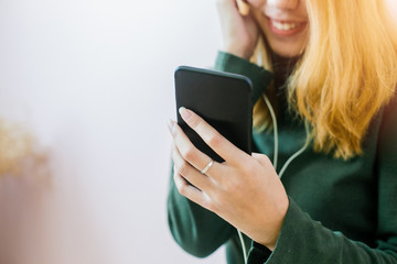 Fototapeta premium woman is listening music by her smartphone and feeling chill. Close-up of her phone