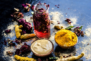 Ayurvedic ubtan of turmeric/haldi and mulpani mitti or fuller’s earth with rose water on a black...