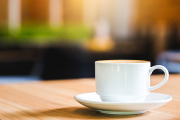 Latte Coffee in a cup on wooden table and Coffee shop blur background