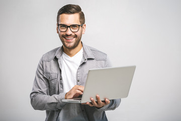Confident business expert. Confident young handsome man in shirt holding laptop, looking at camera and smiling while standing against white background - Powered by Adobe